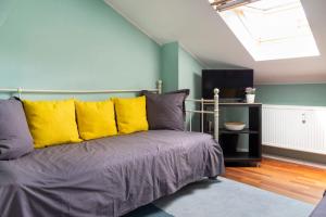 a bedroom with a bed with yellow pillows at Rosenthaler Calling - Rooftop Apartment in Berlin