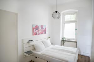 Un dormitorio blanco con una cama y una ventana. en Spacious Apartment in Berlin Mitte for 6, en Berlín