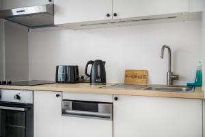 Una cocina con gabinetes blancos y un fregadero. en Spacious Apartment in Berlin Mitte for 6, en Berlín