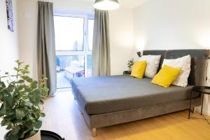 a bedroom with a bed with yellow pillows and a window at 122 Luruper 2 in Hamburg