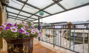 a vase filled with purple flowers on a balcony at Zhangjiajie April Hostel in Zhangjiajie