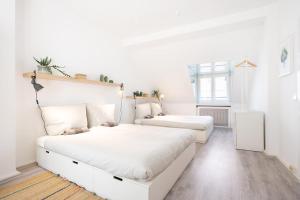 a white bedroom with two beds and a window at 131 Schaefflerstr in Munich