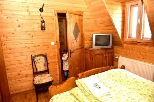 a little girl standing in the corner of a bedroom at PENSIUNEA VESELIA in Botiza