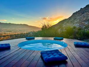 a swimming pool on a wooden table with a sunset at Neon Moon An Elevated Experience w Pool and Spa in Joshua Tree
