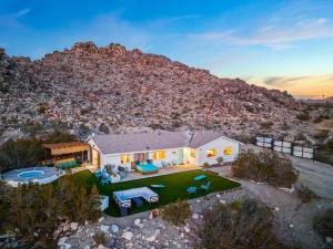an aerial view of a house with a mountain in the background at Neon Moon An Elevated Experience w Pool and Spa in Joshua Tree