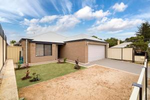 a house with a garage in a yard at Spacious 4BR House Right Near The Beach - Fast WIFI and Massive 85' TV in Geraldton