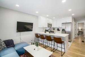 a living room with a blue couch and a kitchen at 2BR in Heart of Queen Village - walk to everything! in Philadelphia