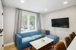 ein Wohnzimmer mit einem blauen Sofa und einem Tisch in der Unterkunft 2BR in Heart of Queen Village - walk to everything! in Philadelphia