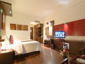 a bedroom with a bed and a desk and a television at Memoire d' Angkor Boutique Hotel in Siem Reap