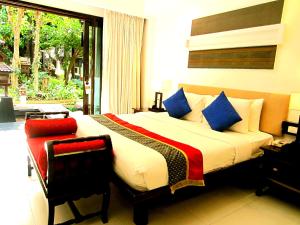 a bedroom with a large bed with blue and red pillows at Yantarasri Resort in Chiang Mai