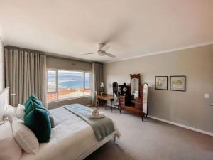 a bedroom with a large bed with a large window at Dizzy Hill Villa with 270° Breathtaking Views. Pool + Patio in Plettenberg Bay