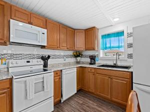 - une cuisine avec des appareils blancs et des armoires en bois dans l'établissement Little Cove Resort, 