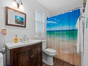 La salle de bains est pourvue d'un lavabo, de toilettes et d'un rideau de douche. dans l'établissement Little Cove Resort, à Taft 14 autres photos