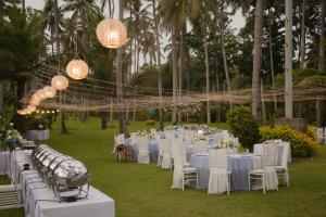 una recepción de bodas con mesas y sillas blancas y lámparas de araña en Candi Beach Resort & Spa, en Candidasa 76 fotos más