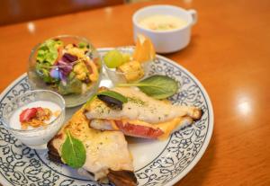 a plate of food with a sandwich and salad on a table at Heiwadai Hotel Tenjin in Fukuoka