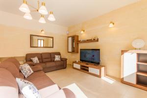un soggiorno con un divano e una televisione di Nadurin, Large Villa 7 Bedrooms - 2 Pools a Nadur Altre 28 foto