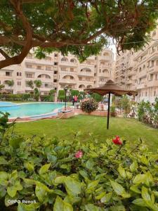 a large building with a swimming pool in a park at Chalet At Wahet Al Nakhil resort in Alexandria