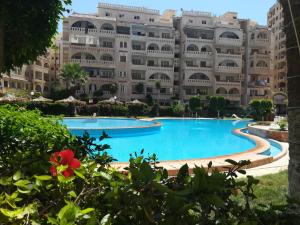 een groot gebouw met een groot zwembad ervoor bij Chalet At Wahet Al Nakhil resort in Alexandrië