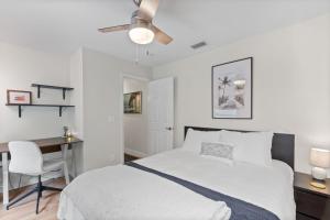 una camera bianca con letto e scrivania di Castile Oasis - Minutes to Beaches & State Park a St. Augustine