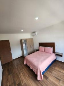 1 dormitorio con cama rosa y suelo de madera en Dpto Playa Centro Malecón Plza Machado¡Promoción! en Mazatlán