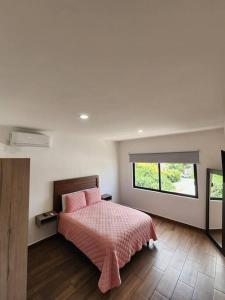 una camera da letto con un letto con cuscini rosa e una TV di Dpto Playa Centro Malecón Plza Machado¡Promoción! a Mazatlán
