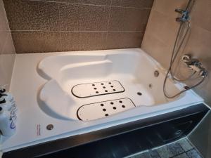 Fox Motel في دايغو: حوض استحمام مع دش في الحمام