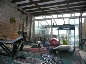 un gimnasio con cintas de correr y máquinas en una habitación en Au Clos d'Ardennes, en Balaives-et-Butz