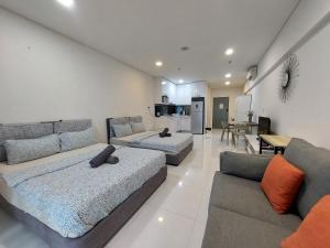 uma sala de estar com duas camas e um sofá em Inspired Homes @ Summer Suite em Kuala Lumpur