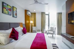a hotel room with a large bed with pink pillows at Saltstayz Grand Sky - Unitech Cyber Park in Gurgaon