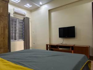 a bedroom with a bed and a flat screen tv at S23 homestay in Hai Phong