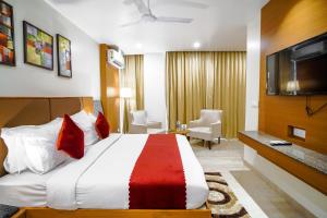 een hotelkamer met een groot bed en een televisie bij Saltstayz Grand Sky - Unitech Cyber Park in Gurgaon
