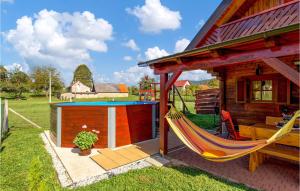 eine Hängematte, die an einem Haus mit Pool befestigt ist in der Unterkunft Gorgeous Home In Licko Lesce in Ličko Lešće