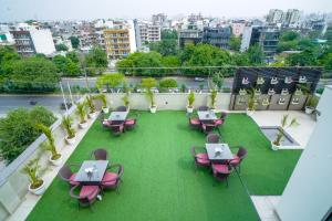 Elle dispose d'un balcon avec des tables, des chaises et des ordinateurs portables. dans l'établissement Saltstayz Grand Sky - Unitech Cyber Park, à Gurgaon