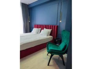 a bedroom with a bed and a green chair at 360 Tbilisi in Tbilisi City