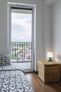 een slaapkamer met een bed en een groot raam bij ENERGYLANDIA Zator Apartament Krzyś in Zator
