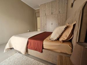 Schlafzimmer mit einem großen Bett mit Kopfteil in der Unterkunft Christa's Home near ATH Airport in Markopoulo