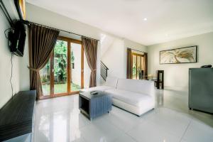a living room with a white couch and a tv at Abisha Villa Jimbaran in Jimbaran