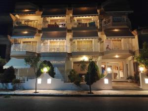 a large white building at night with lights at Villa Zeus INN in Paralia Katerinis