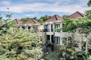 an exterior view of a house with trees at Abisha Villa Jimbaran in Jimbaran