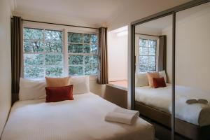sypialnia z 2 łóżkami i dużym oknem w obiekcie Federation Gardens & Possums Hideaway w mieście Blackheath