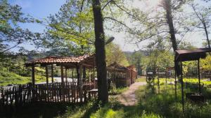 a wooden fence with a gazebo in a park at Guesthouse - Family Hotel in Bagdatʼi