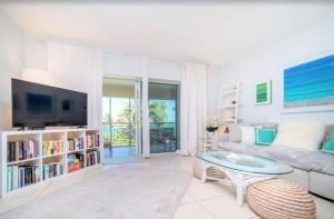 a living room with a couch and a tv at Beach Living at the Retreat in Driftwood Village