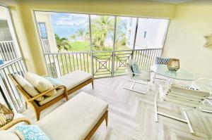 a living room with a balcony with a table and chairs at Beach Living at the Retreat in Driftwood Village