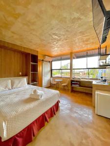 1 dormitorio con cama grande y ventana grande en La Zona Hostel, en San Salvador