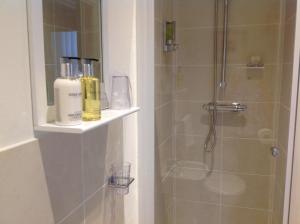 a bathroom with a shower with two bottles on a shelf at 3 Cambridge Villas in Ambleside +82 photos