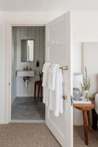 uma casa de banho com toalhas brancas penduradas numa porta em The Bentley Inn em Bay Head