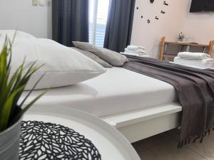 a bed with white sheets and pillows in a room at Apartments Ana & Ita in Novalja