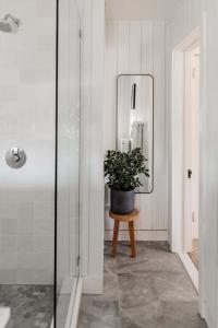 a bathroom with a mirror and a potted plant at The Bentley Inn in Bay Head