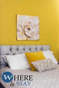 a bedroom with a bed with a flower painting on the wall at Entire Modern House City Center in Barrow in Furness