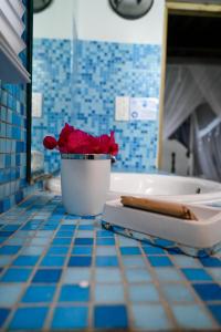 baño con bañera y maceta de flores en la encimera en The Cottages - Unit 1 en Soufrière